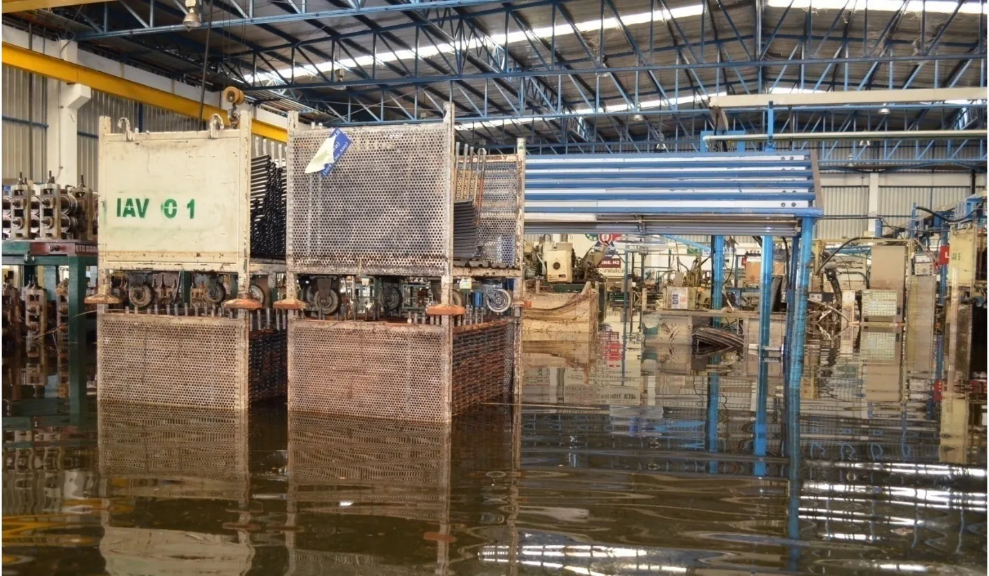 Production line machinery standing in floodwater on a factory floor